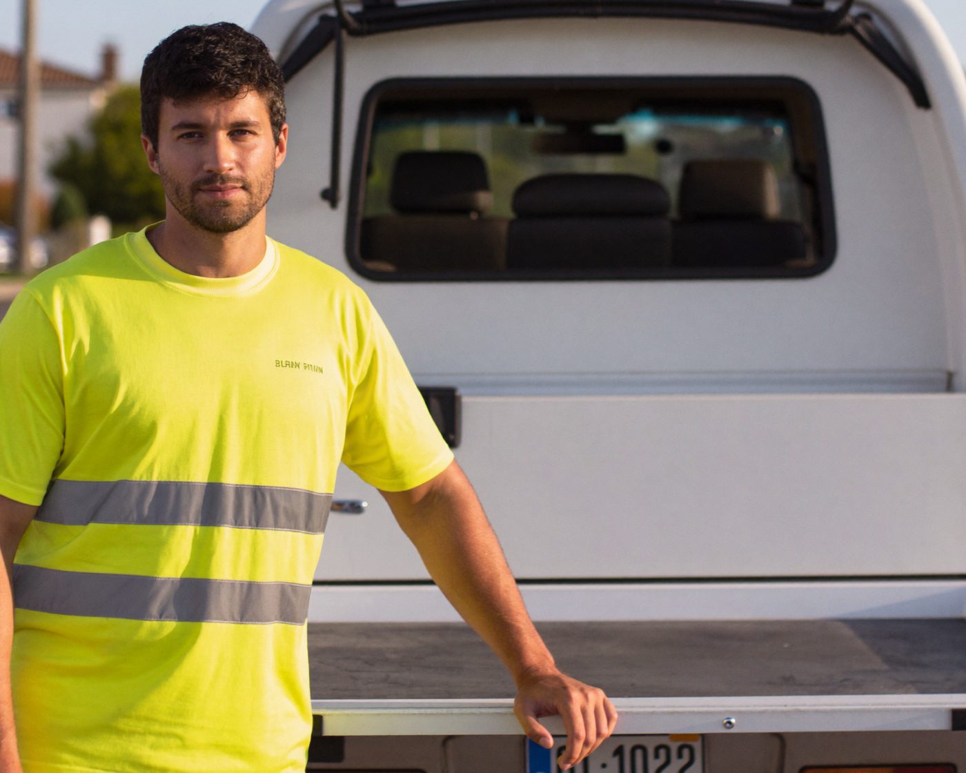 A tradesman standing at the tray of his new white work ute